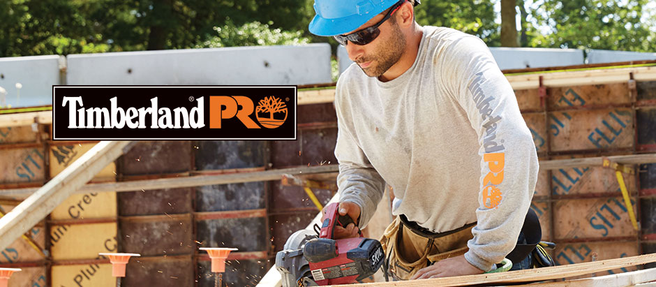 Image of a man using a table saw outside. Timberland Pro logo is overlaid.